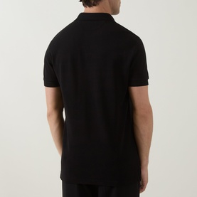 Model wearing Tom Ford black cotton polo shirt, rear view showing clean back panel and short sleeves