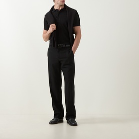 Model wearing Tom Ford black cotton polo shirt with black trousers and leather belt, styled with black loafers.
