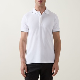 Model wearing Tom Ford white and black polo shirt with contrast tipped collar and cuffs, styled with black trousers