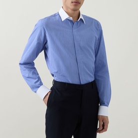 Model wearing Tom Ford Stripe Contrast Shirt in blue and white with pointed collar, white contrast cuffs, styled with navy trousers