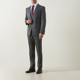Model wearing Tom Ford grey wool suit with slim-fit trousers, styled with a white shirt, red striped tie, and dark brown oxford shoes.