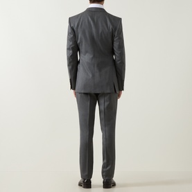 Model wearing Tom Ford grey wool suit, back view, tailored two-piece with slim-fit trousers, styled with black dress shoes.