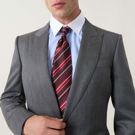 Model wearing Tom Ford grey wool suit jacket, styled with a blue striped shirt and red striped tie