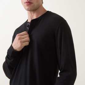 Model wearing Tom Ford black long-sleeve wool-silk-cashmere T-shirt, shown from chest up, gripping neckline
