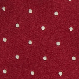Red fabric with scattered cream polka dot pattern, close-up texture detail