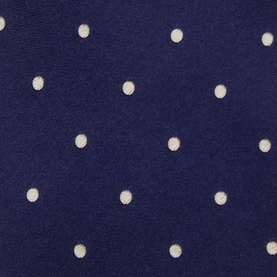 Navy blue fabric with scattered cream polka dot pattern, close-up texture detail