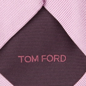Tom Ford pink silk tie, close-up showing diagonal stripe texture and embroidered logo label in dark contrast lining