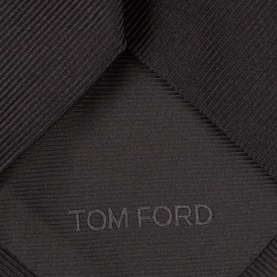 Tom Ford black silk tie, close-up showing tonal diamond weave texture and embossed logo detail