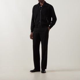 Model wearing Tom Ford black virgin wool zip-through knit with leather patches, styled with black tailored trousers and black leather shoes.
