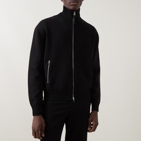 Model wearing Tom Ford black virgin wool zip-through knit jacket with silver zip detail and leather patches.