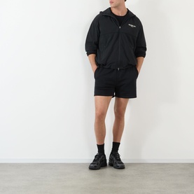 Model wearing 247 Jet Black casual jacket with matching black shorts and black chunky trainers.