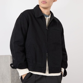 Model wearing Almost Home OG Twill Jacket in Storm Black, zip-front cotton casual jacket with collar, styled over white layered top.