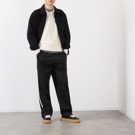 Model wearing Almost Home OG Twill Jacket in Storm Black with cream hoodie, black wide-leg trousers and black trainers with tan soles.