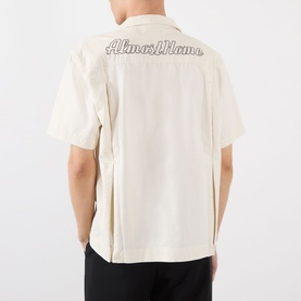 Model wearing Almost Home Logo Bowling Shirt in Cloudskin, showing embroidered script logo across the back, short sleeves and straight hem.