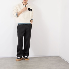 Model wearing Almost Home Cloudskin cotton polo with AH logo, styled with black wide-leg trousers and white flatform trainers