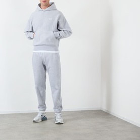 Model wearing Almost Home Workwear Logo Sweatpants in Gym Grey, tapered leg with cuffed ankles, styled with matching grey hoodie and white trainers