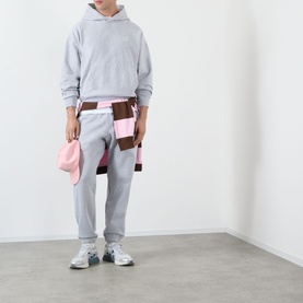 Model wearing Almost Home Gym Grey Workwear Logo Sweatpants, styled with matching grey hoodie, pink tote bag and patchwork apron.