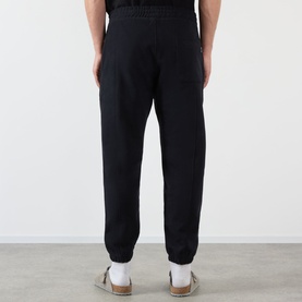 Model wearing Almost Home Workwear Logo Sweatpants in Porto Black, tapered leg with cuffed ankles and elasticated waistband, back view