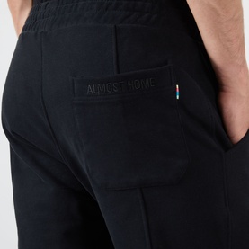 Almost Home Workwear Logo Sweatpants in Porto Black, close-up of rear patch pocket with tonal logo embroidery and multicolour flag detail.