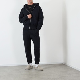 Model wearing Almost Home Workwear Logo Zip Hoodie in Porto Black with matching black joggers and grey suede loafers