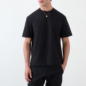 Model wearing Almost Home Workwear Logo T-Shirt in Porto Black, crew neck, dropped shoulders, tonal chest logo embroidery, styled with black trousers