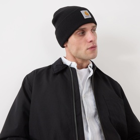 Model with Carhartt Watch Logo Beanie in black, knit with turned-up brim and woven logo badge, styled with black jacket and white shirt
