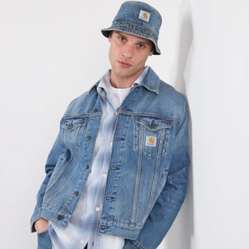 Model with Carhartt Belmar Denim Bucket Hat in blue, styled with matching denim jacket and white shirt
