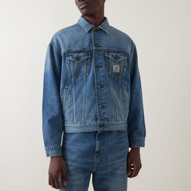 Model wearing Carhartt Helston Denim Jacket in Blue Splatter, mid-wash heavyweight denim, shirt collar, front button fastening, styled with blue