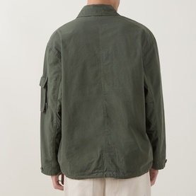 Model wearing Carhartt Mandelson Logo Field Jacket in Leaf green, back view showing sleeve patch pocket and relaxed fit.