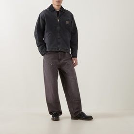 Model wearing Carhartt OG Detroit Jacket in Black with wide-leg dark washed jeans and black leather shoes.