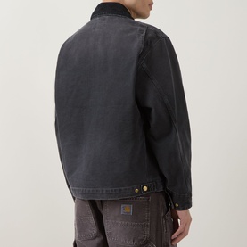 Model wearing Carhartt OG Detroit Jacket in Black, rear view showing corduroy collar, gold hardware and destroyed wash finish, styled with dark cargo