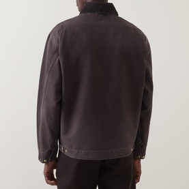 Model wearing Carhartt OG Detroit Logo Jacket in Tobacco, back view, heavyweight cotton canvas with snap button hem and dropped shoulders