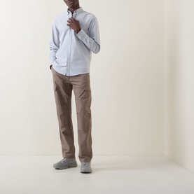 Model wearing Carhartt C-Logo Patch Pocket Shirt in Shady Grey/White, paired with taupe trousers and grey trainers.