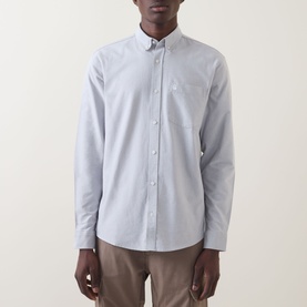Model wearing Carhartt C-Logo Patch Pocket Shirt in Shady Grey/White, long-sleeve button-down with chest pocket, styled with beige trousers