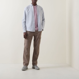 Model wearing Carhartt C-Logo Patch Pocket Shirt in Shady Grey/White, styled with a pink tee, tan cargo trousers and grey trainers.