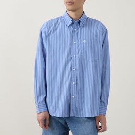 Model wearing Carhartt Keene Stripe Shirt in Curacao blue stripe, button-down collar, long sleeves, chest pocket, styled with light wash jeans