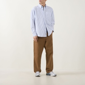 Model wearing Carhartt Casual Shirt in Keene Stripe/White, styled with tan wide-leg trousers and grey trainers.