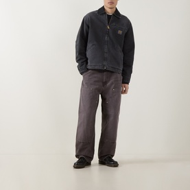 Model wearing Carhartt OG Double Knee Straight Jeans in Tobacco, loose straight cut with double-layer knees, styled with a dark zip jacket and