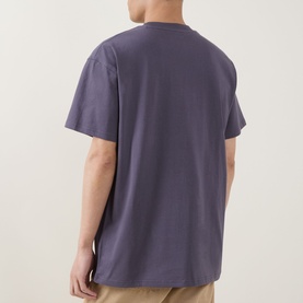 Model wearing Carhartt American Script Logo T-Shirt in Shady Purple, back view, crew neck, short sleeves, relaxed fit, 100% cotton