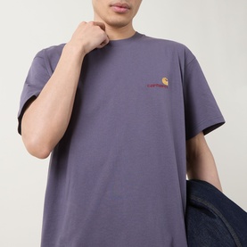 Model wearing Carhartt American Script Logo T-Shirt in Shady Purple, crew neck with short sleeves and small chest logo, styled with blue denim