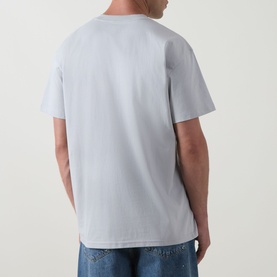 Model wearing Carhartt Bumper Stickers Logo T-Shirt in Pontiki blue, crew neck, short sleeves, styled with light wash jeans. Back view.