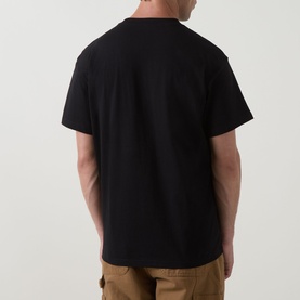 Model wearing Carhartt Bumper Stickers Logo T-Shirt in black, rear view, crew neck, short sleeves, styled with tan cargo trousers.