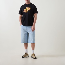 Model wearing Carhartt Cheese Toast T-Shirt in black with cheese toastie graphic, styled with light blue denim shorts and chunky trainers.
