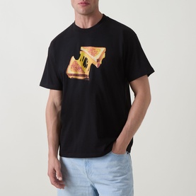 Model wearing Carhartt Cheese Toast T-Shirt in black with cheese toastie graphic print on front, styled with light blue jeans.