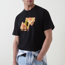 Model wearing Carhartt Cheese Toast T-Shirt in black with melting cheese toastie graphic print, styled with light blue jeans.