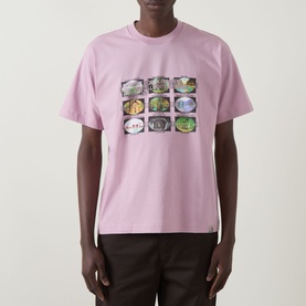 Model wearing Carhartt Coordinates Logo T-Shirt in Hortensia pink with nine-panel coordinate graphic print on chest, paired with dark trousers.
