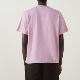 Model wearing Carhartt Coordinates Logo T-Shirt in Hortensia, rear view showing dropped shoulders and straight hem, styled with dark trousers.