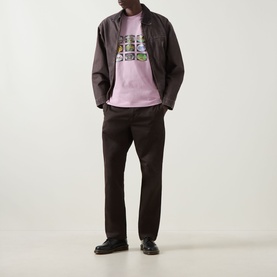 Model wearing Carhartt Coordinates Logo T-Shirt in Hortensia pink with graphic print, styled with dark brown jacket and trousers, black loafers.