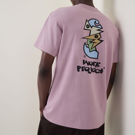 Model wearing Carhartt Cubist Logo T-Shirt in Hortensia pink, back view showing Cubist character graphic print and Work Project text.