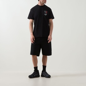 Model wearing Carhartt Playing Cards Logo T-Shirt in black with matching black shorts and chunky trainers.